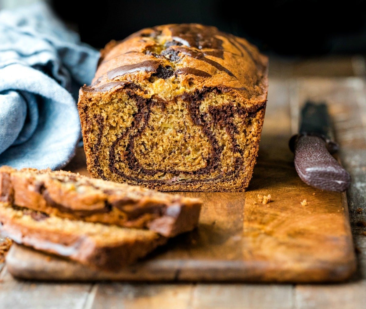 Loaf of marbled Banana Bread next to a bread knife