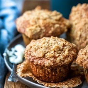 Butter knife with butter on it next to banana crumb muffins
