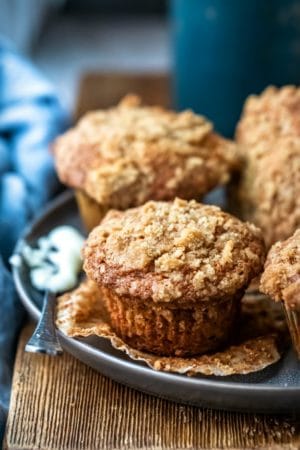 Butter knife with butter on it next to banana crumb muffins