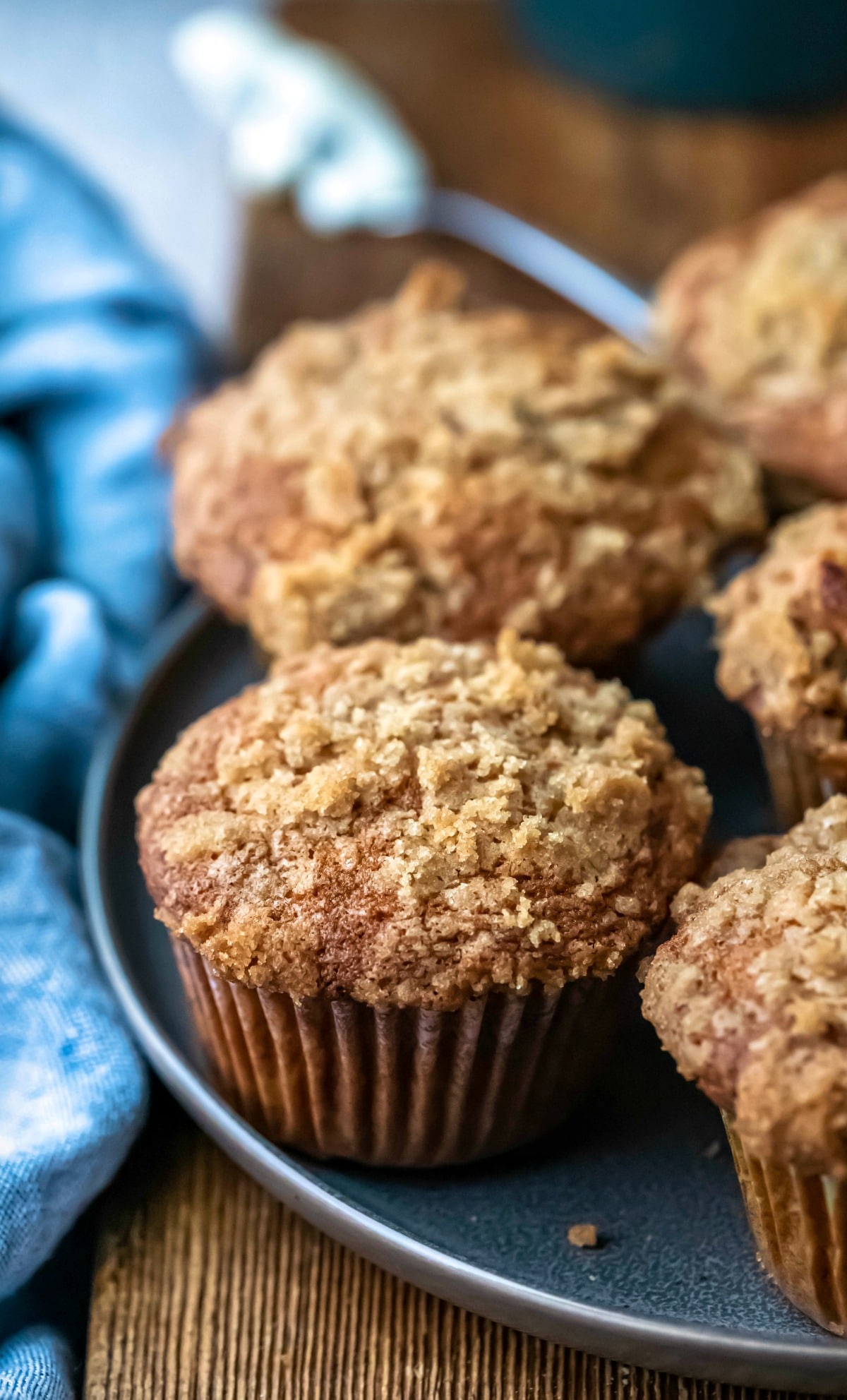 Plate of banana crumb muffins next to a blue linen napkin