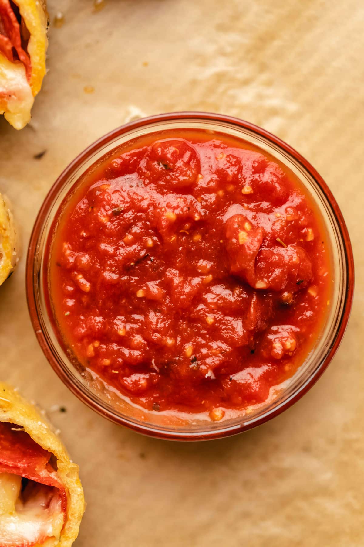 A dish of homemade pizza sauce on a piece of brown parchment paper. 