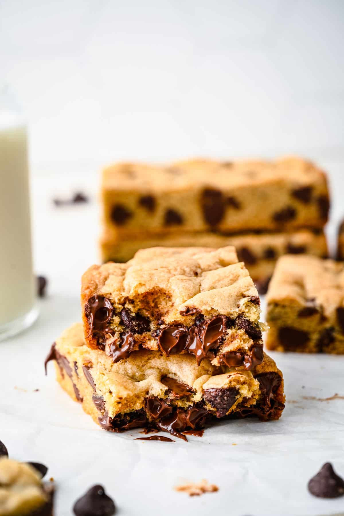 A chocolate chip cookie bar with a bite missing stacked on another cookie bar.