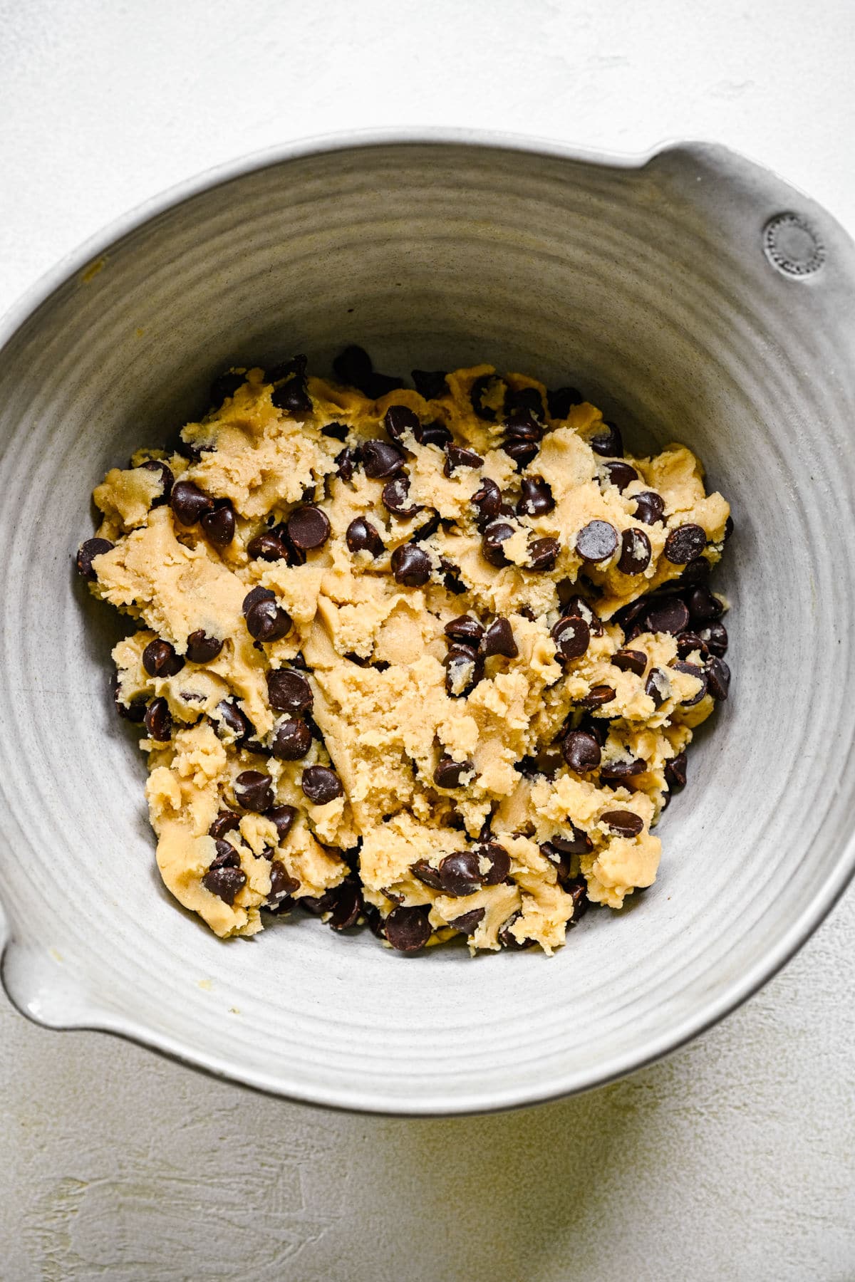 Chocolate chip cookie dough in a mixing bowl. 