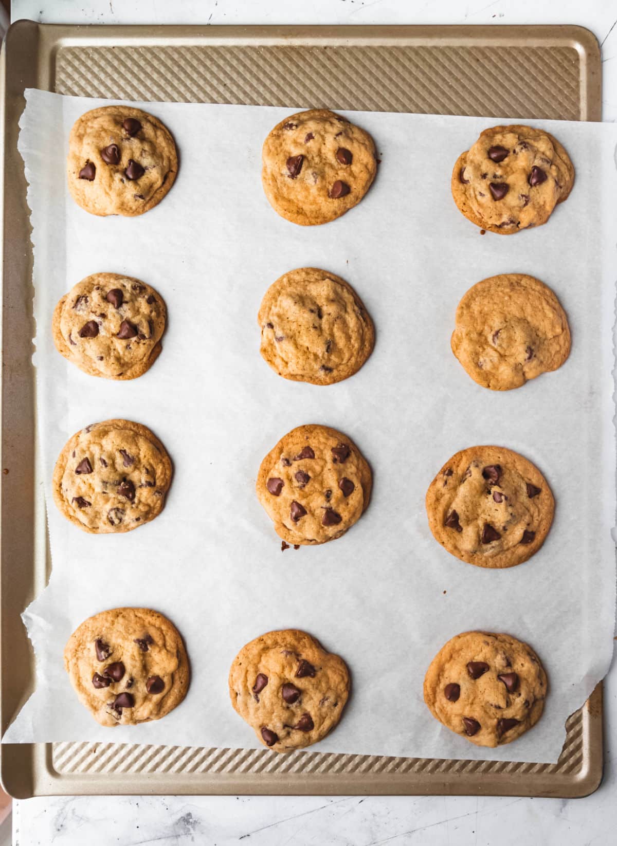 Baked chocolate chip pudding cookies on a baking sheet. 