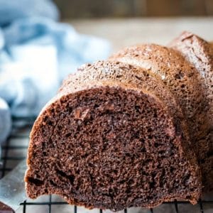 Part of a chocolate bundt cake on a wire cooling rack