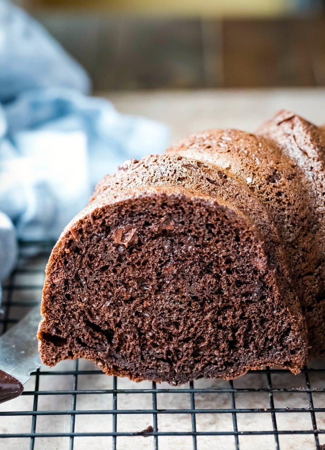 Part of a chocolate bundt cake on a wire cooling rack