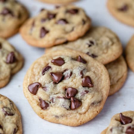 A chocolate chip pudding cookie leaning against a stack of cookies.