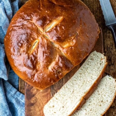 Two slices of bread next to a loaf of skillet bread