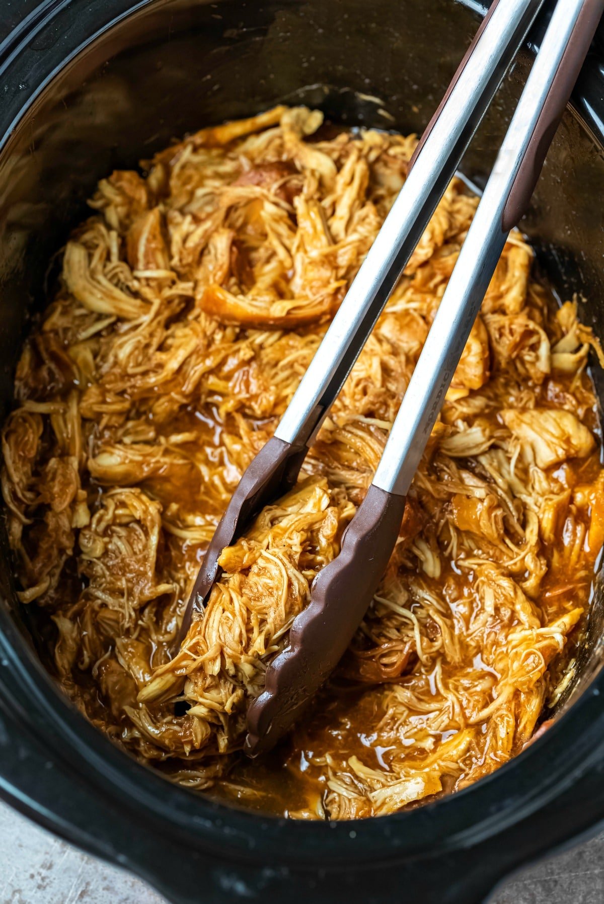 Shredded crock pot brown sugar bourbon bbq chicken in a slow cooker insert