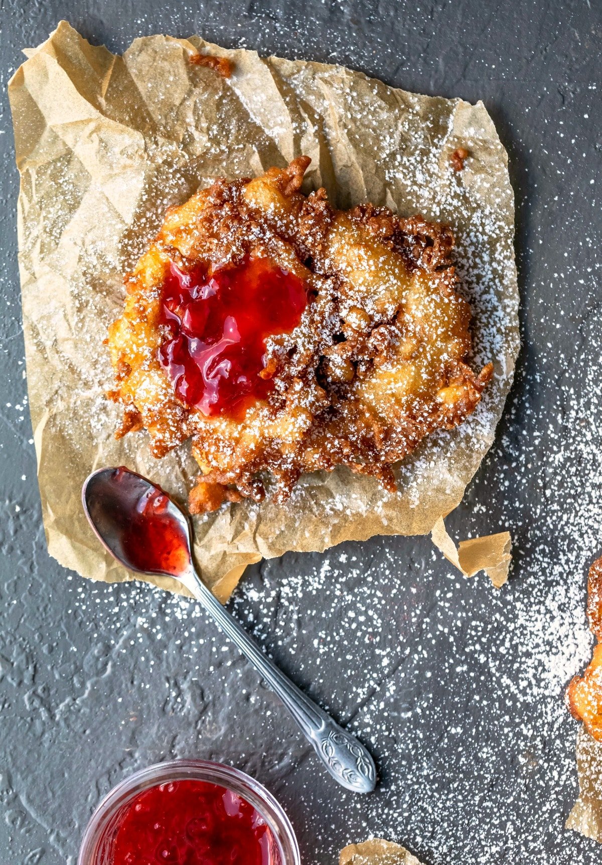 Homemade funnel cake topped with strawberry jam.