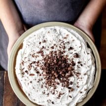 Two hands holding a no bake chocolate pie in a pan
