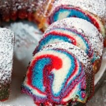 Slices of red, white, and blue marble cake on a cake platter