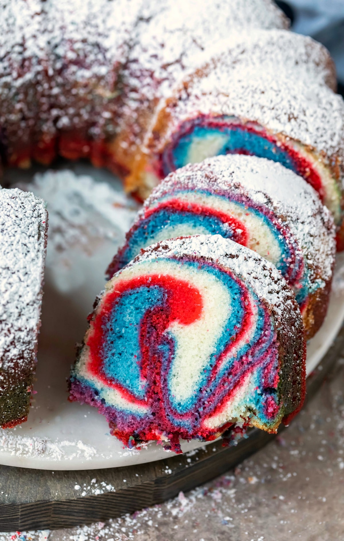 Slices of red, white, and blue marble cake on a cake platter