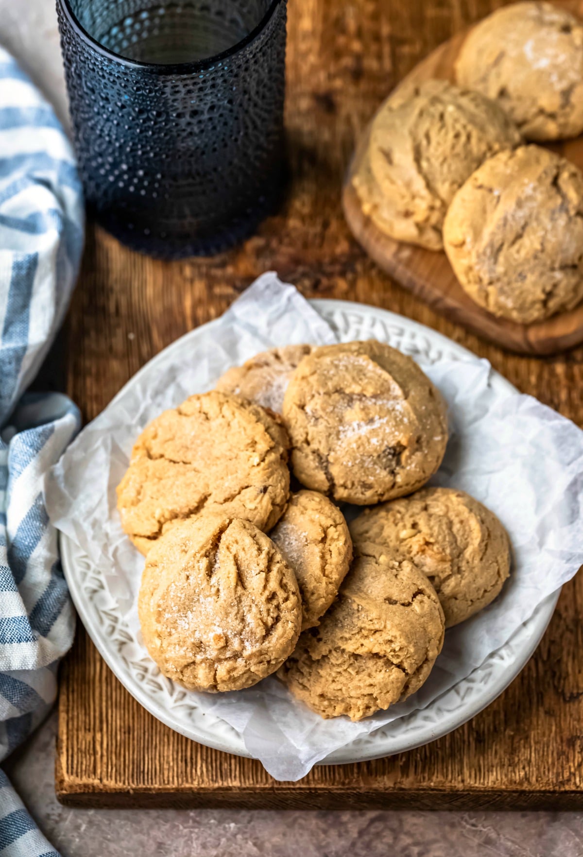 Cream plate full of chewy peanut butter cookies next to a blue striped napkin