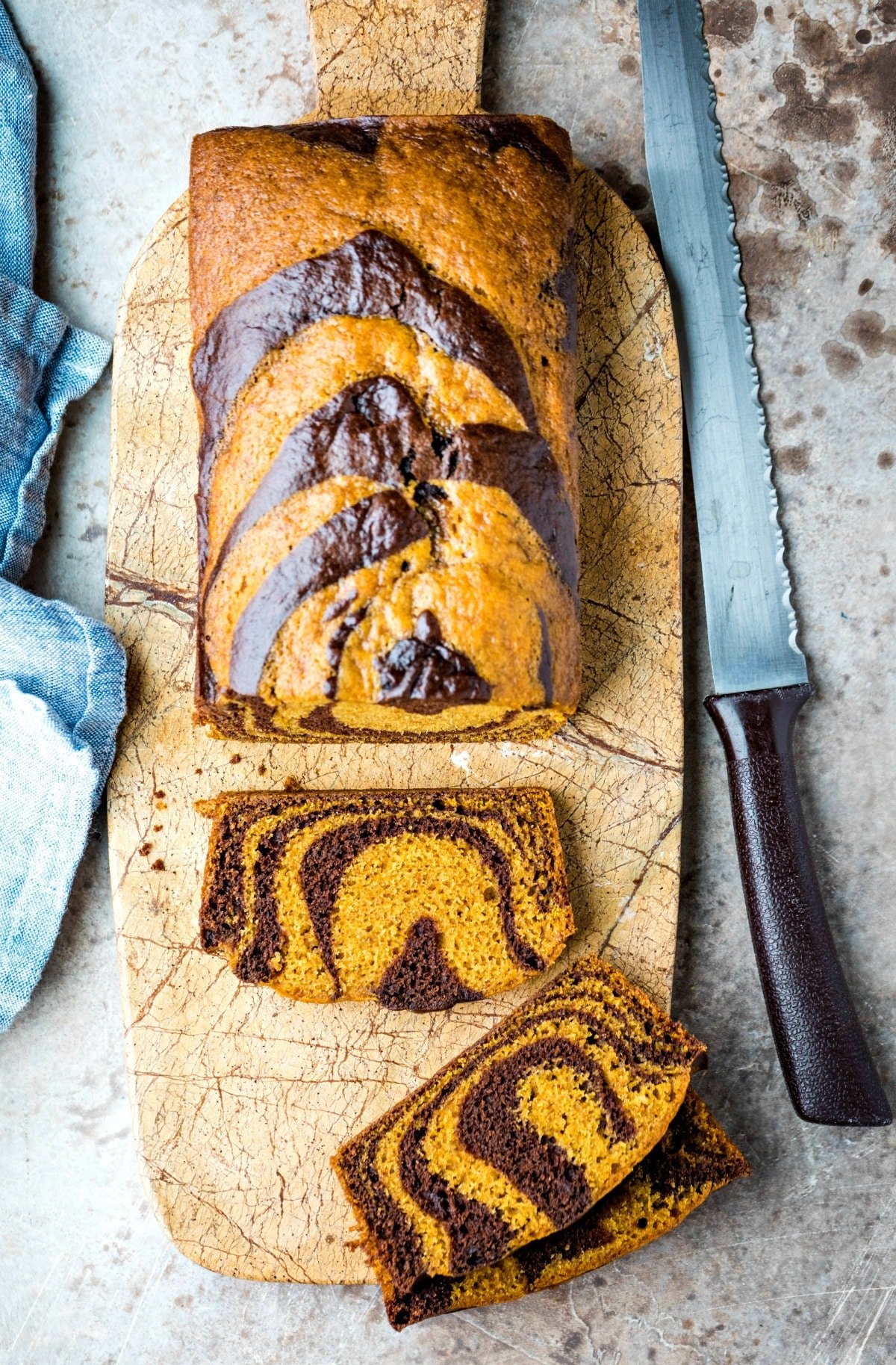 Loaf of chocolate marble pumpkin bread next to a bread knife