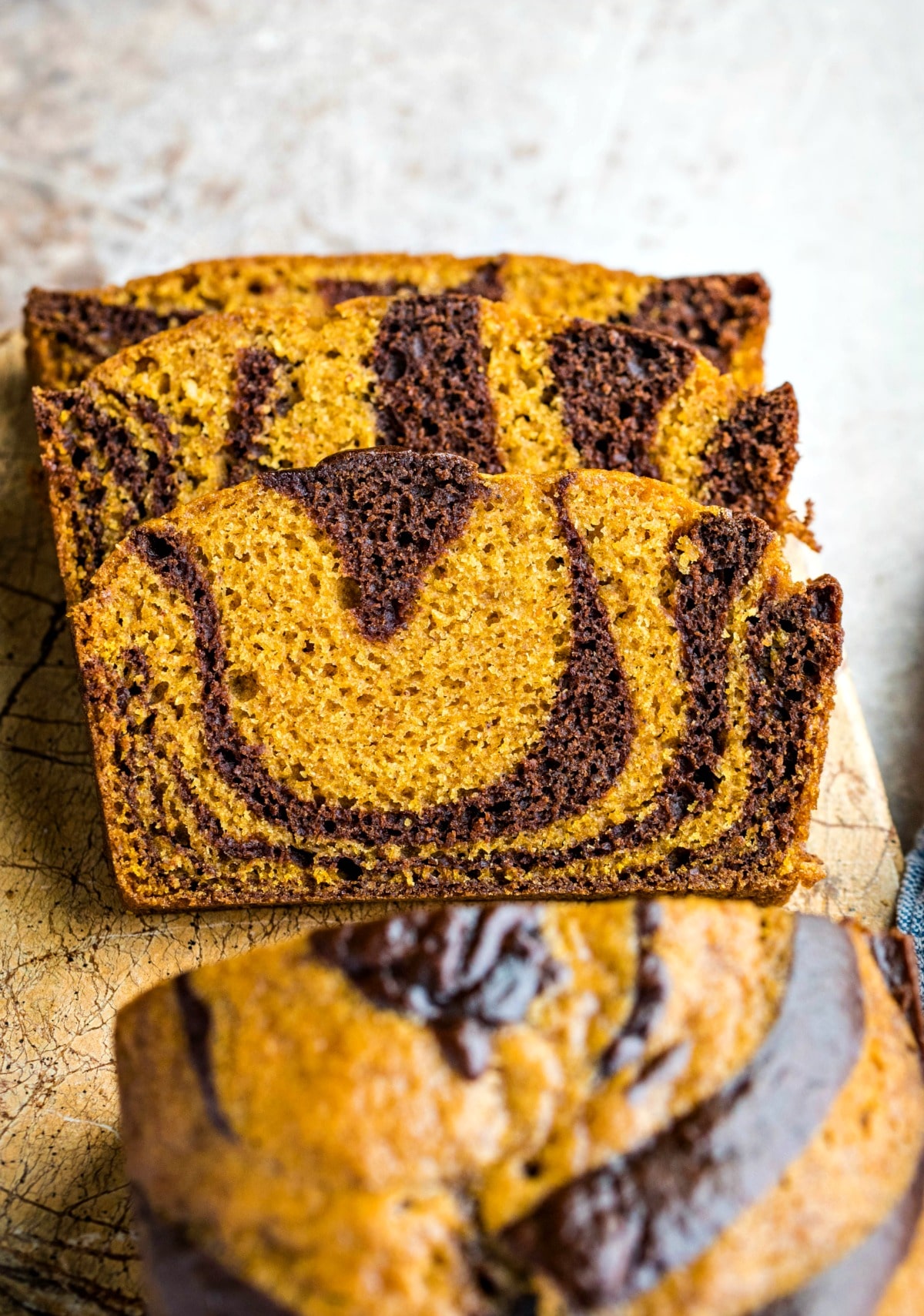 Three stacked slices of chocolate marble pumpkin bread 