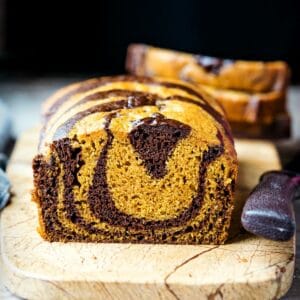 Loaf of chocolate marble pumpkin bread on a marble cutting board