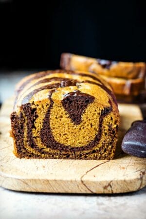 Loaf of chocolate marble pumpkin bread on a marble cutting board