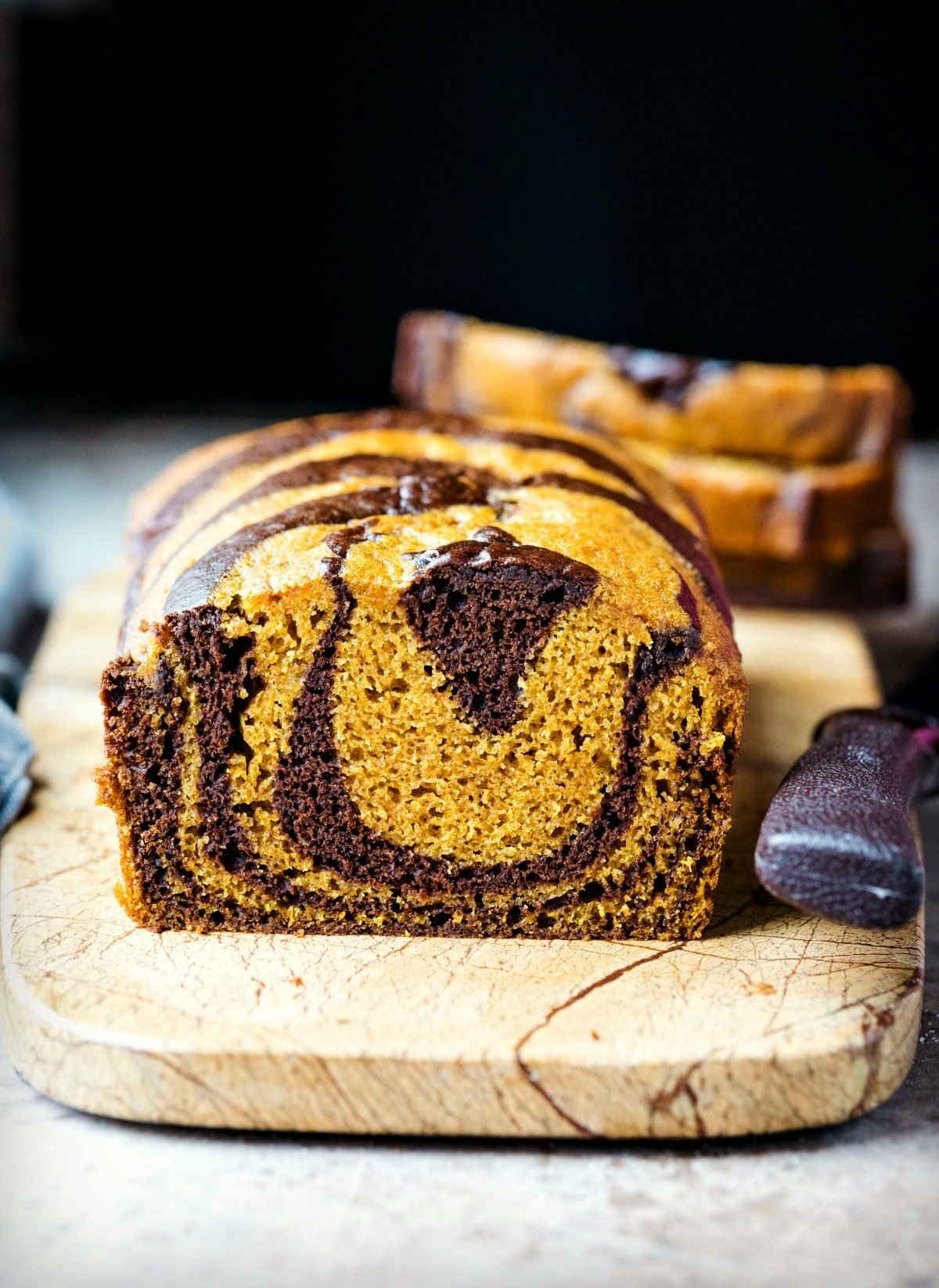 Chocolate Marble Pumpkin Bread Loaf of chocolate marble pumpkin bread on a marble cutting board