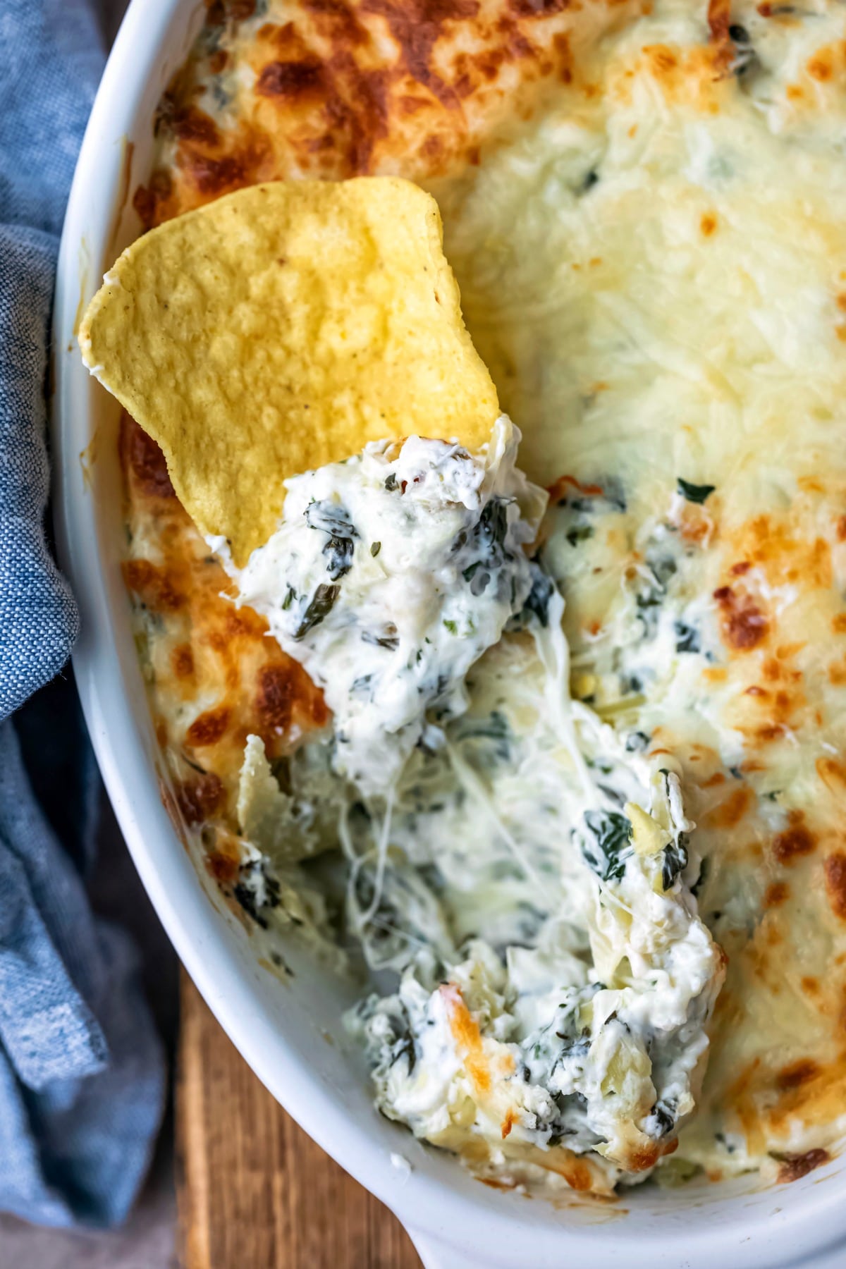 Tortilla chip topped with spinach artichoke dip.