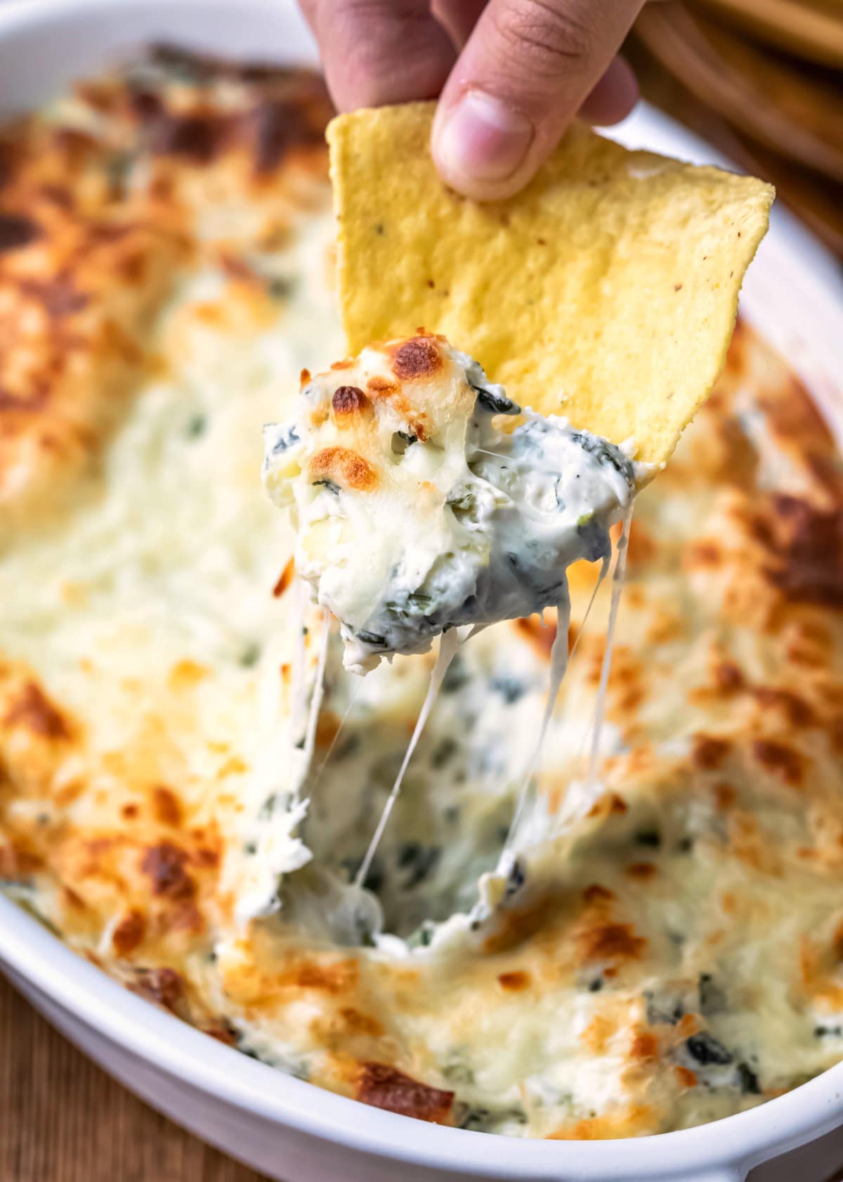 Chip scooping up spinach artichoke dip