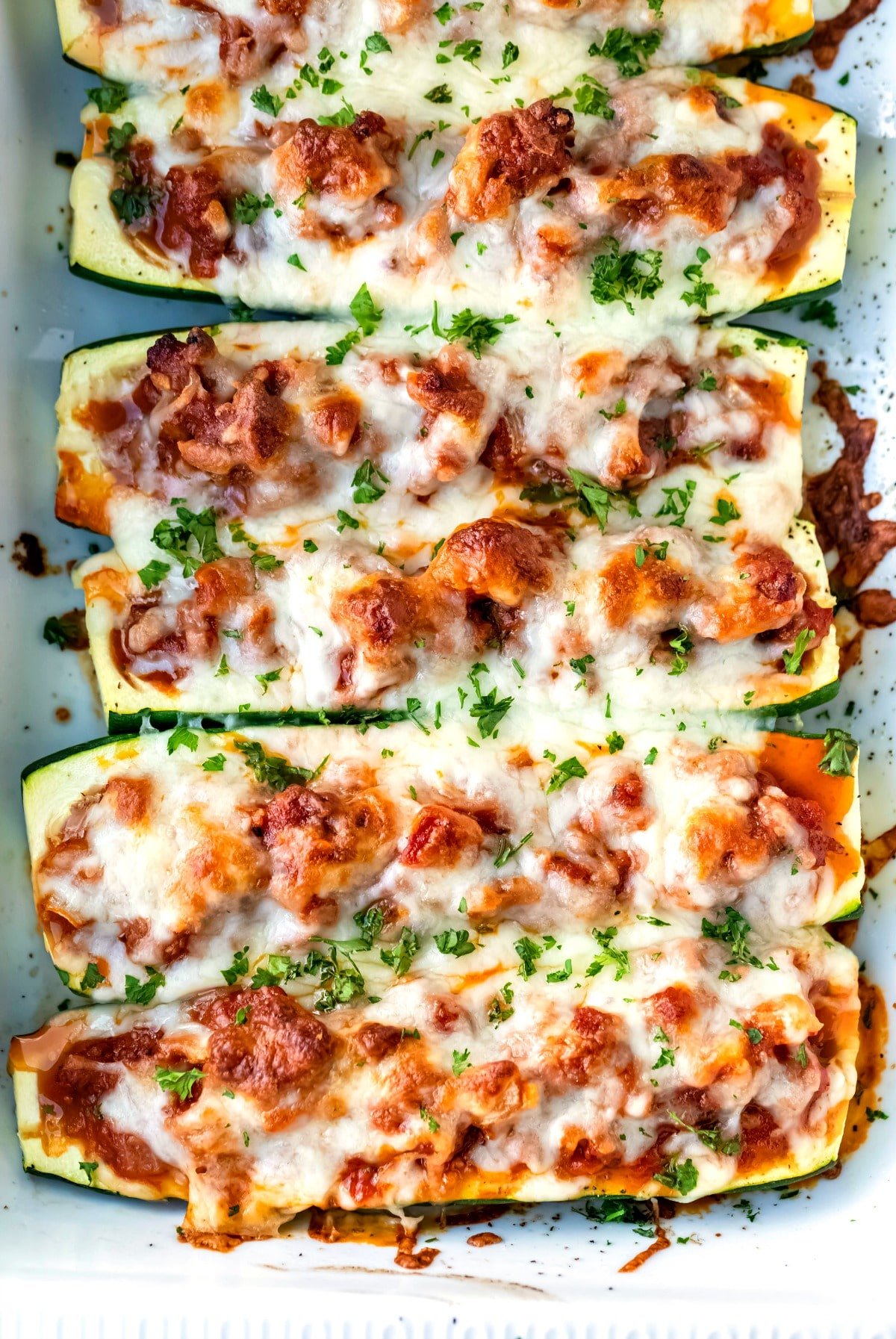 Baked zucchini boats topped with chopped parsley