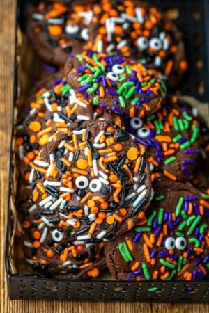 Halloween monster cookies in a black metal tin