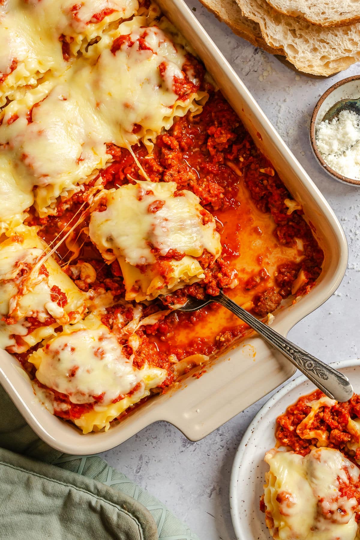 A server under a lasagna roll in a pan.