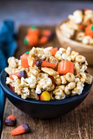 Halloween snack mix in a black wooden bowl