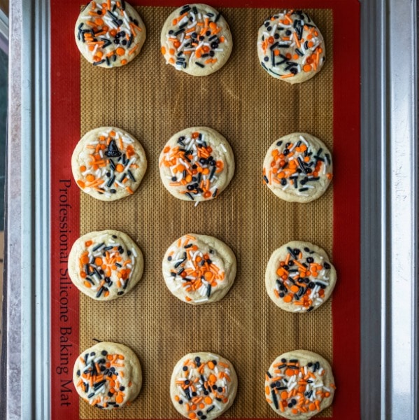 Halloween sprinkle cookies on a silicone baking mat