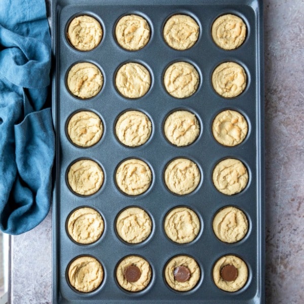 Baked peanut butter cup cookies with peanut butter cups in them.