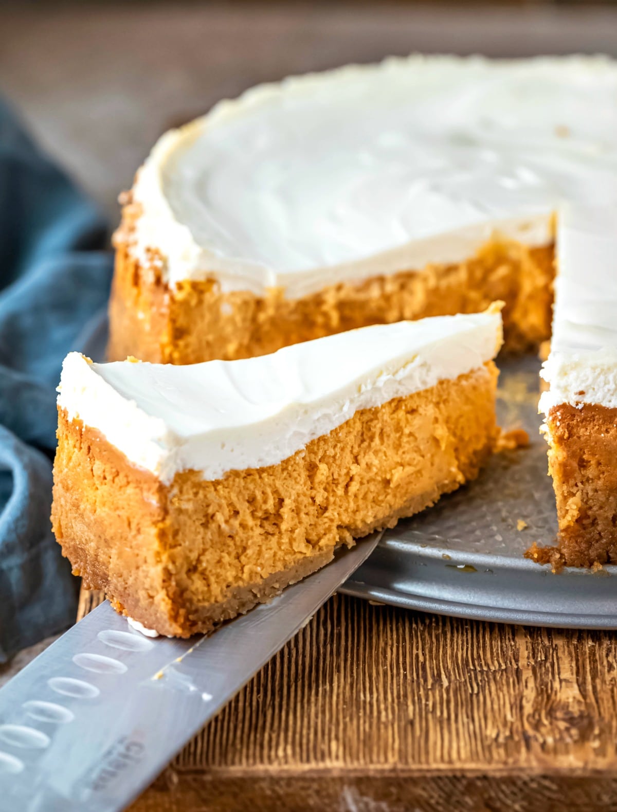 Pumpkin Cheesecake Recipe Slice of pumpkin cheesecake next to the entire cheesecake.