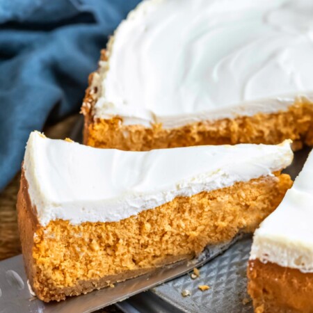 Knife cutting a slice of pumpkin cheesecake.