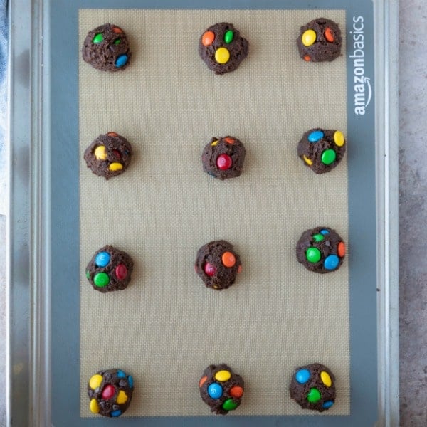 chocolate M&M cookie dough scoops on a baking sheet