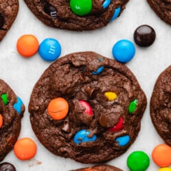 Rows of chocolate M&M cookies on parchment paper.
