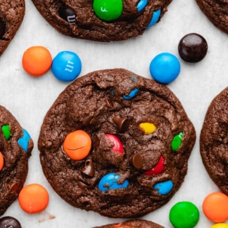 Rows of chocolate M&M cookies on parchment paper.