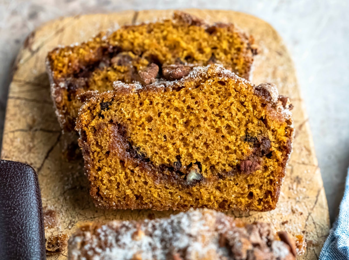 Slices of cinnamon sugar pumpkin bread on a marble cutting board