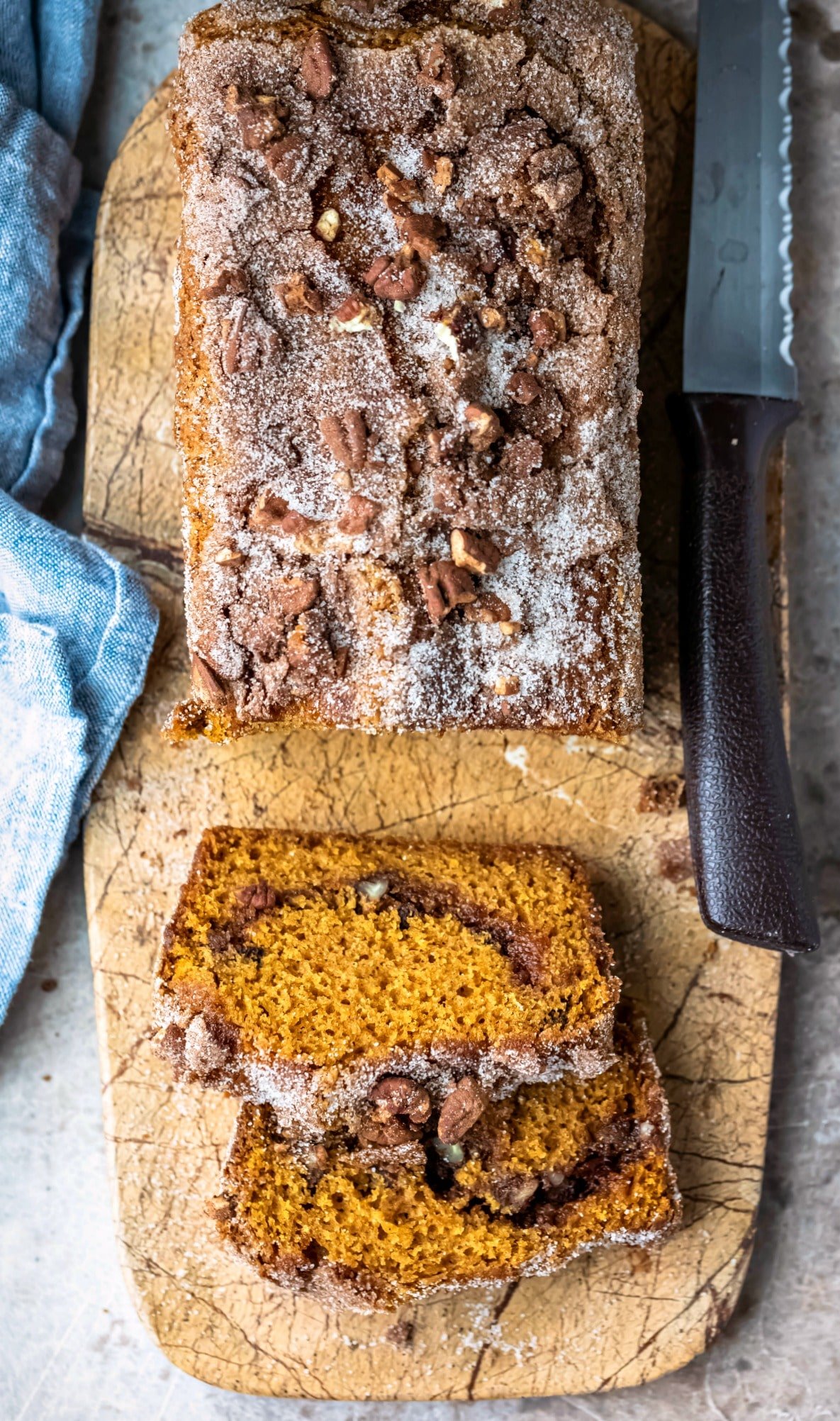 Loaf of cinnamon sugar pumpkin bread on a marble cutting board