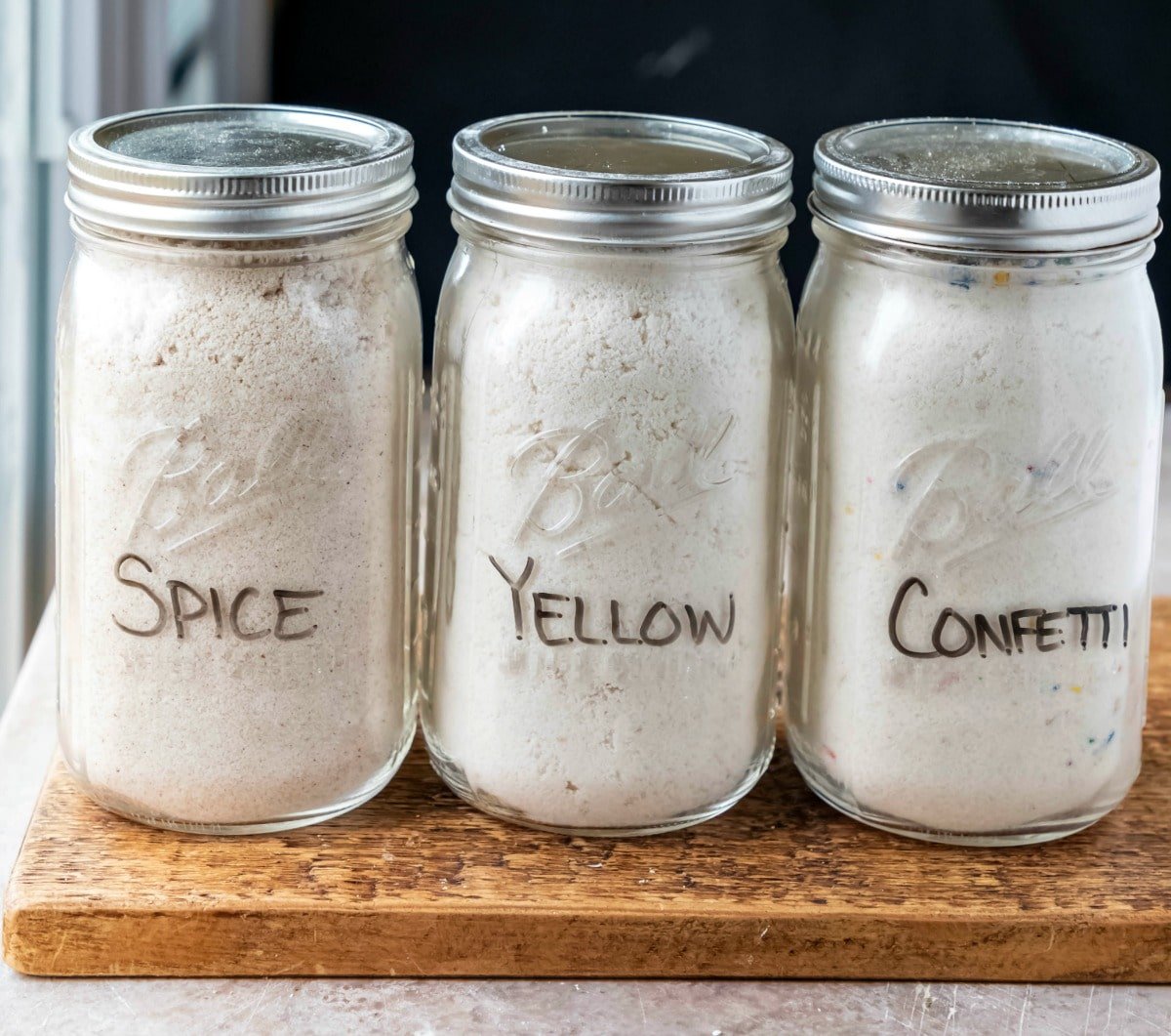 Three jars of homemade cake mix with lids on