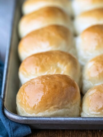 Silver baking tray with a row of one hour dinner rolls on it