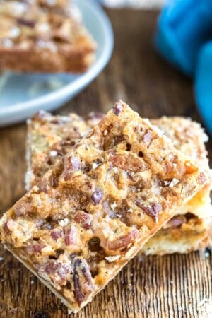 Toffee pecan pie bar leaning up against stack of bars