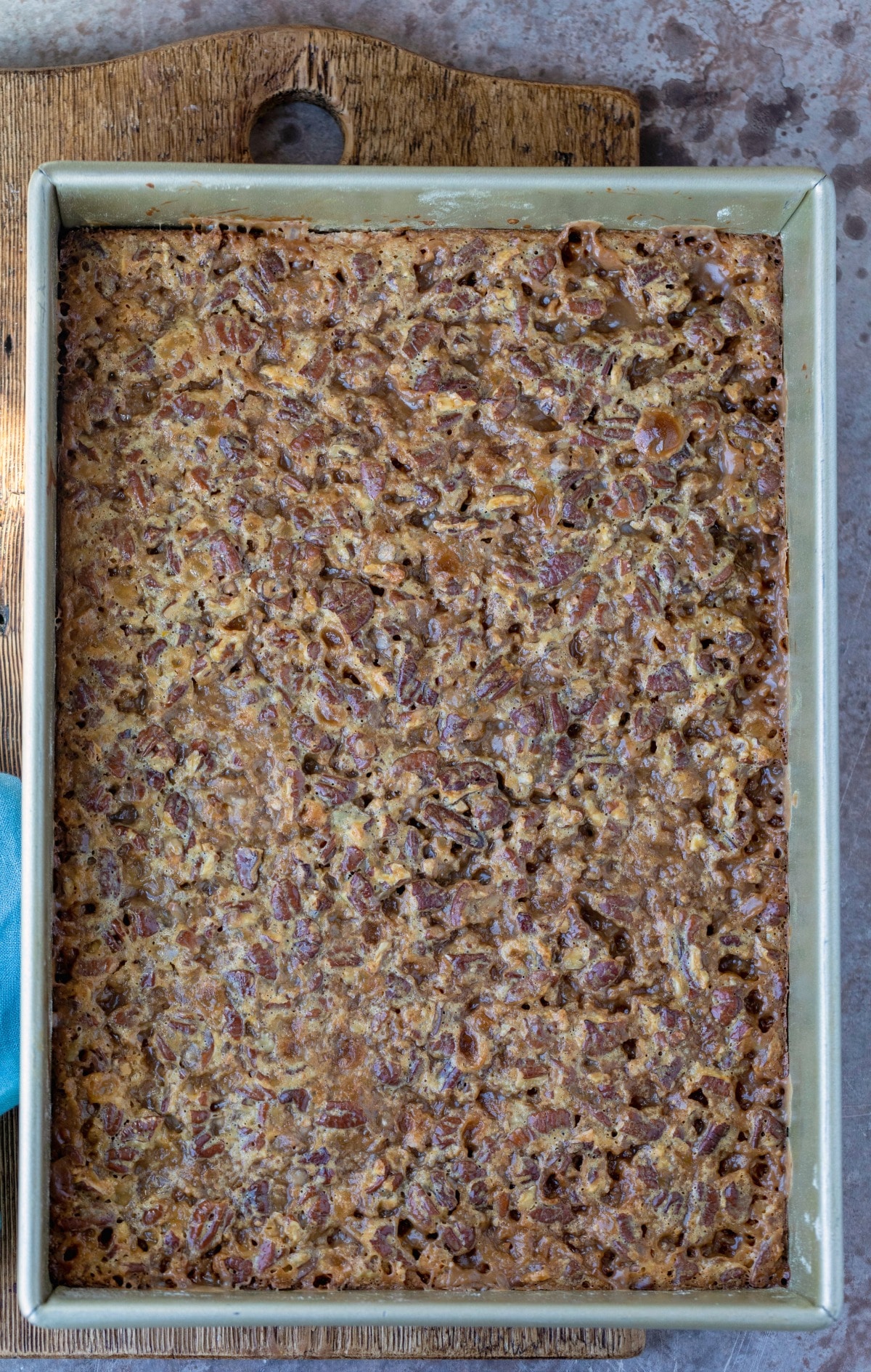 Baked toffee pecan pie bars in a gold baking pan