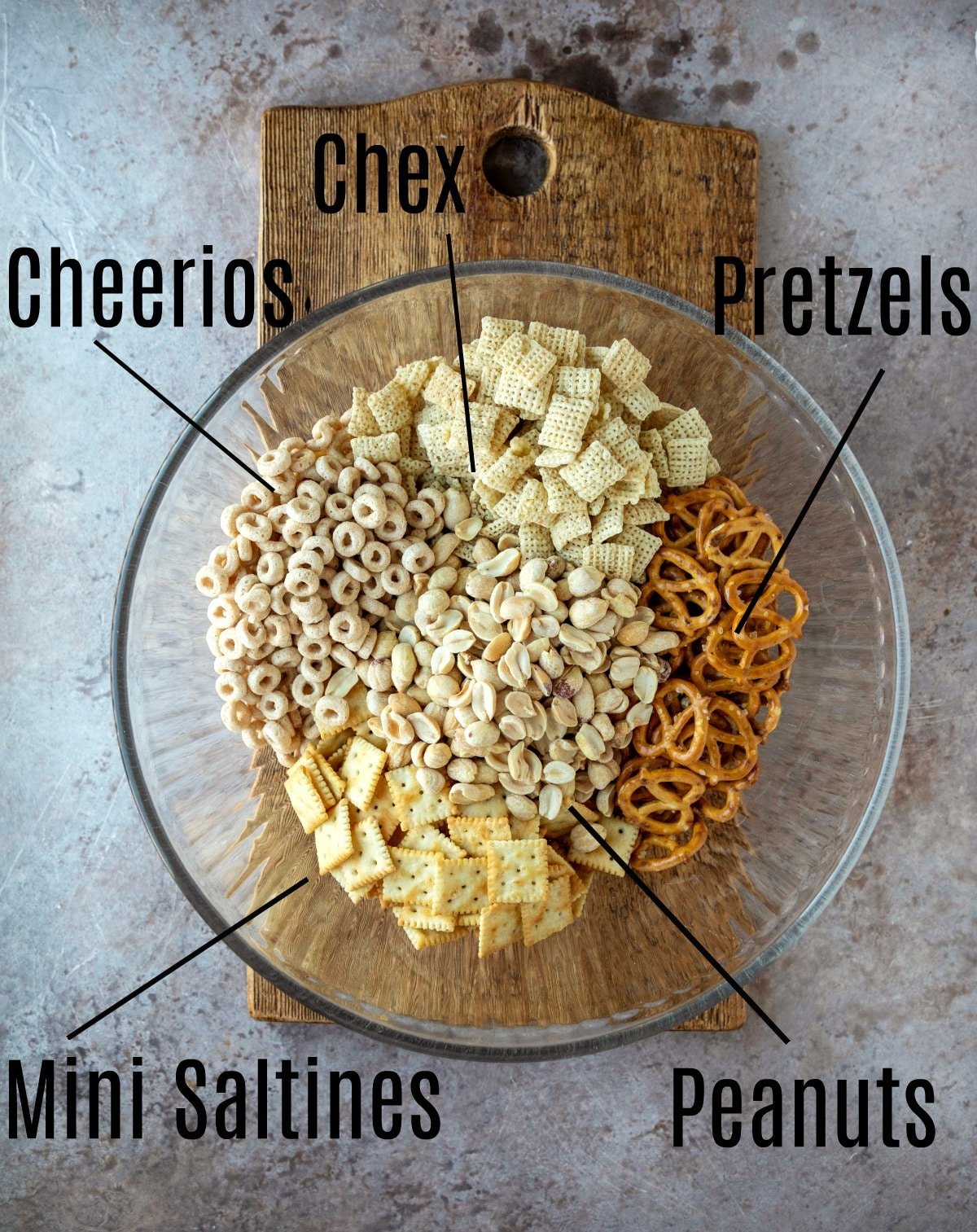 White chocolate party mix ingredients in a glass mixing bowl