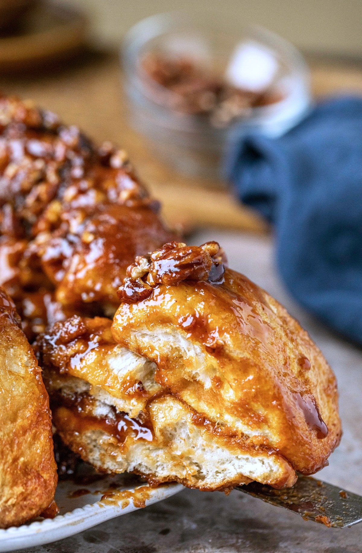 A knife slicing a piece of sticky bun