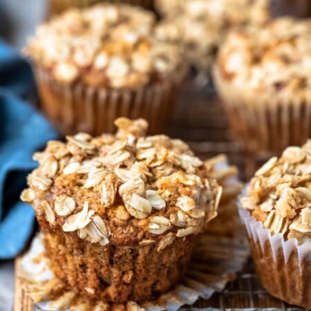 Unwrapped banana oat muffin next to a blue linen napkin