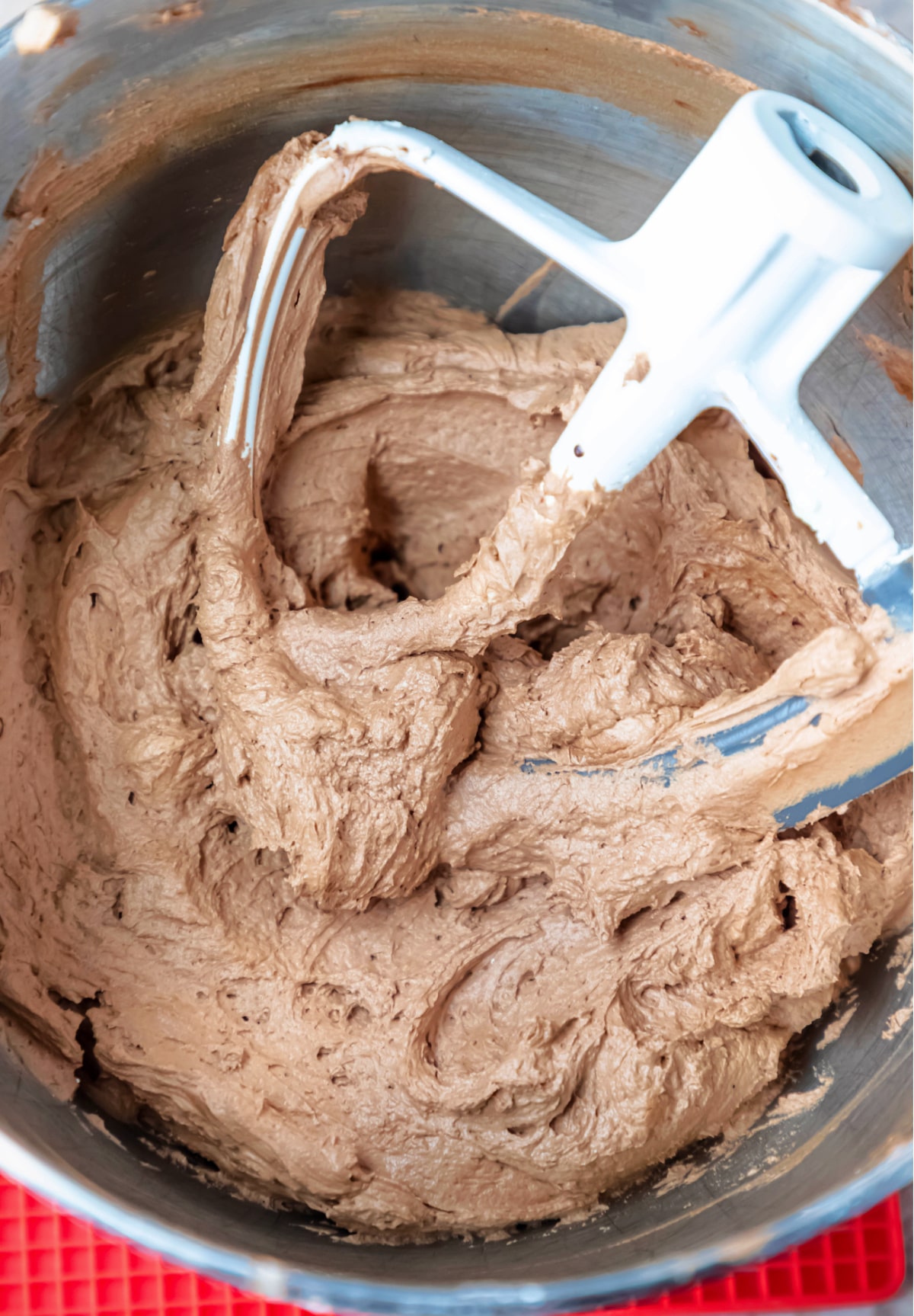 Paddle attachment in a bowl of chocolate buttercream frosting