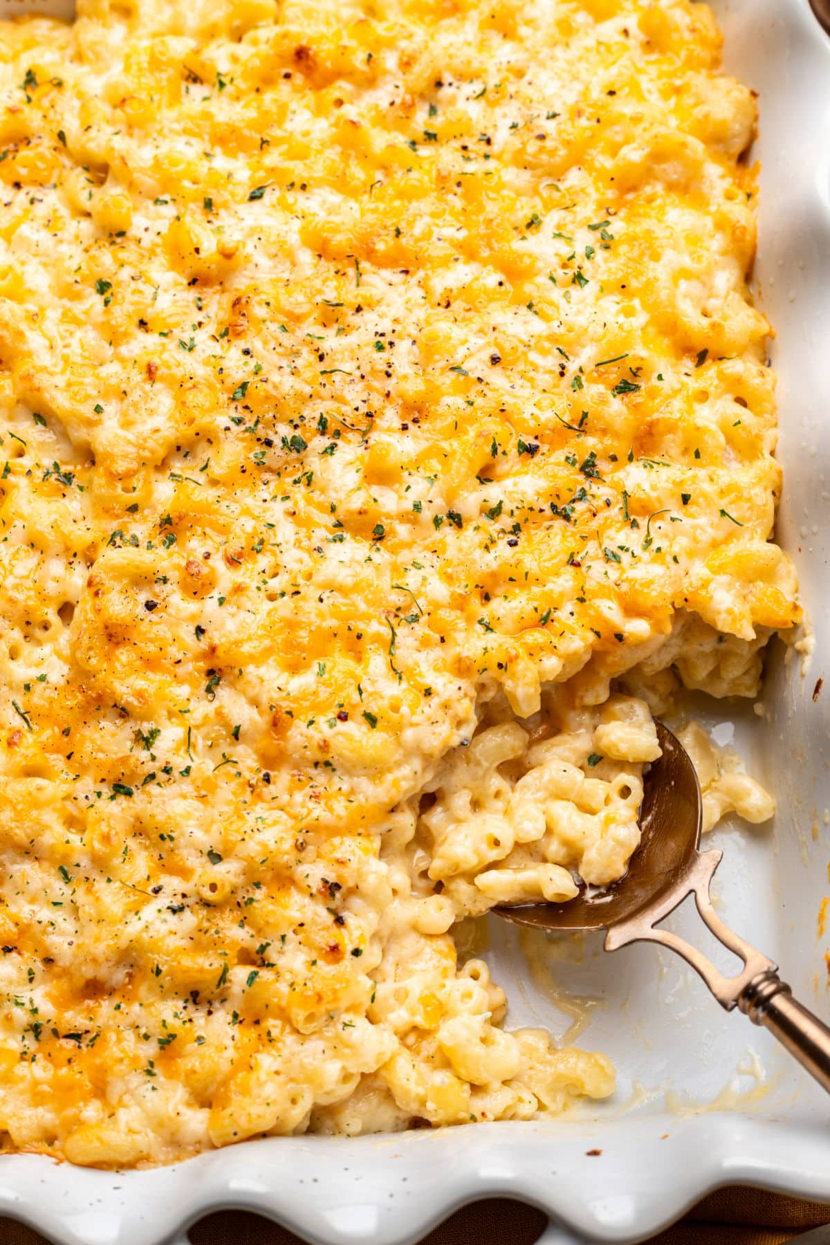 Baked Mac and Cheese A spoon scooping up baked mac and cheese in a dish.