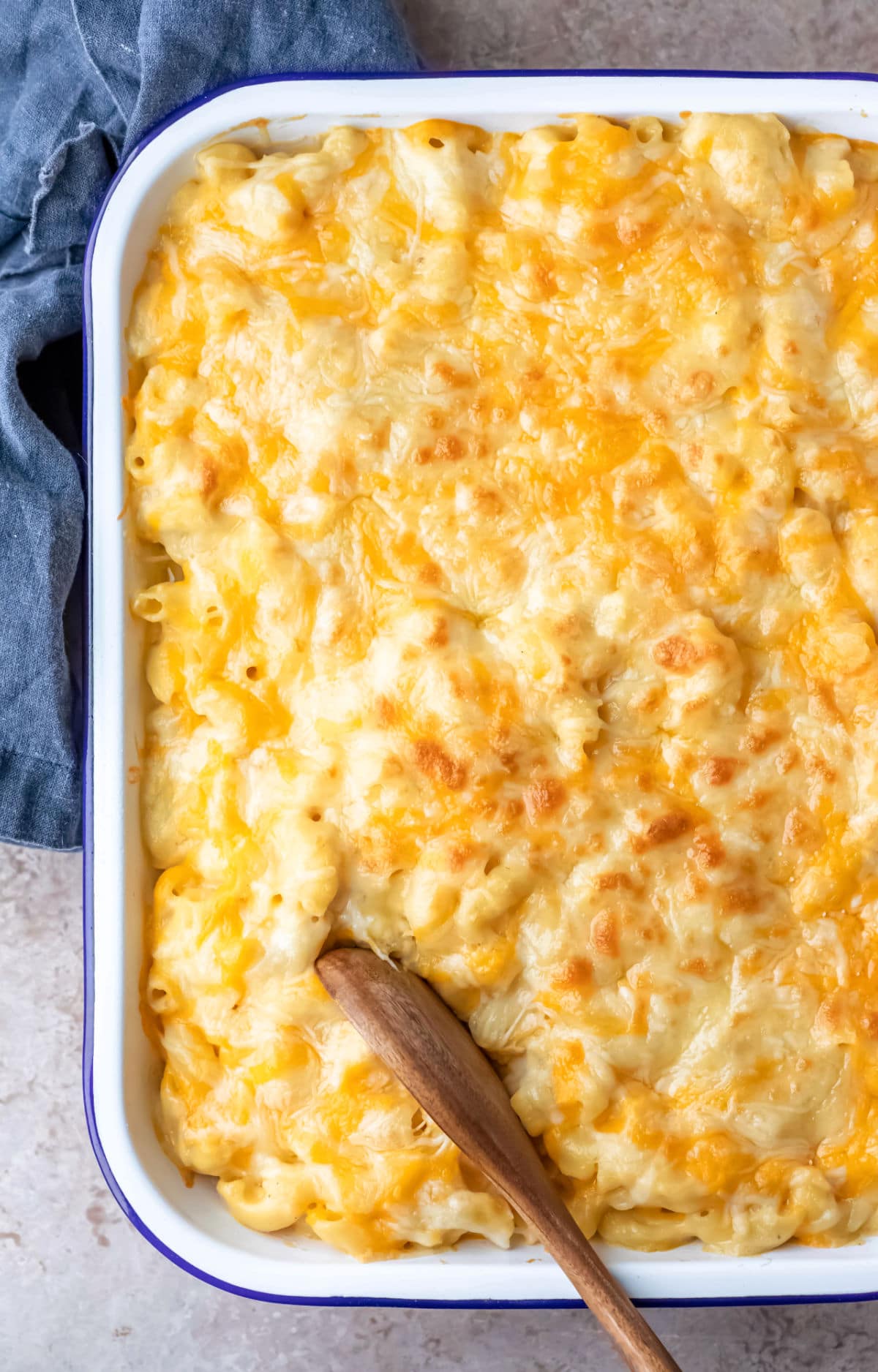 Pan of baked mac and cheese next to a blue linen napkin