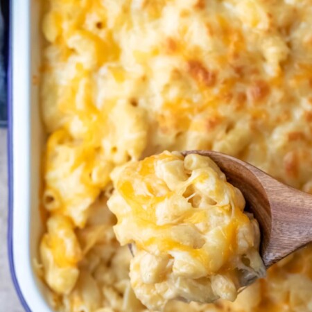 Wooden spoon scooping up baked mac and cheese