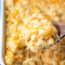 Wooden spoon scooping up baked mac and cheese